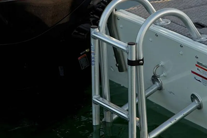 Slide: The Image of 2021 Lowe Sport Deck 224 storage compartment with open hatch, showcasing interior space. - 24