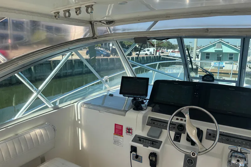 Slide: The Image of 2006 Rampage 38 Express boat helm with navigation equipment and marina view. - 11