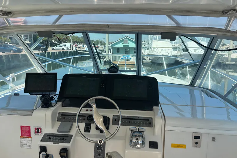 Slide: The Image of 2006 Rampage 38 Express boat helm with navigation screens and steering wheel. - 12