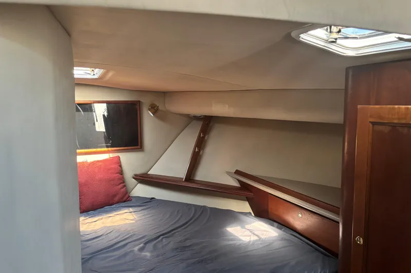 Slide: The Image of 2006 Rampage 38 Express cabin interior with bed, wooden accents, and skylight. - 17