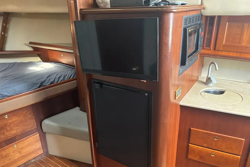 Slide: The Image of 2006 Rampage 38 Express interior with bed, TV, microwave, sink, and wooden cabinetry. - 21