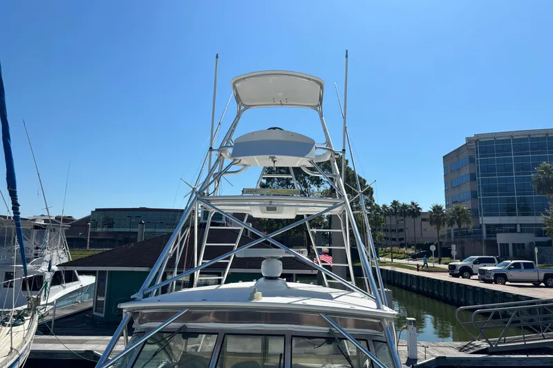 Slide: The Image of 2006 Rampage 38 Express boat docked at marina under clear blue sky. - 27