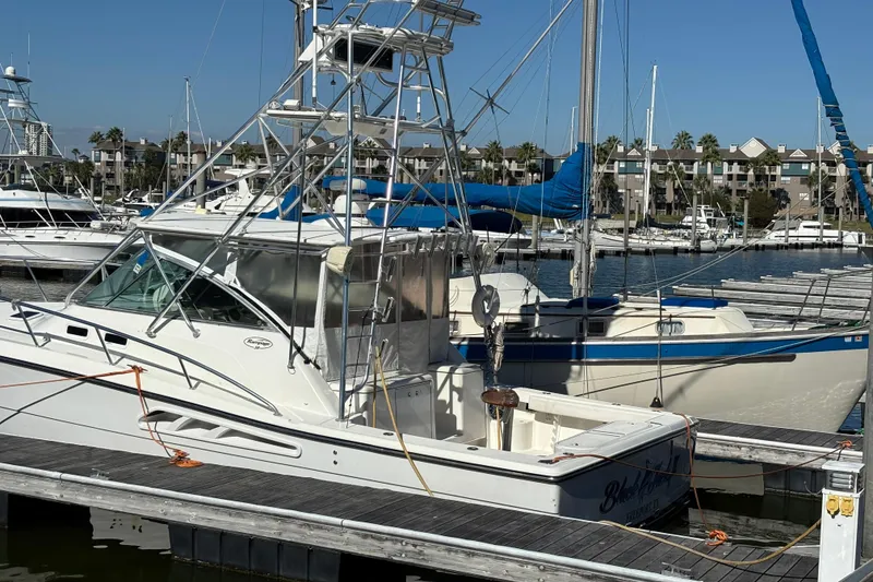 Slide: The Image of 2006 Rampage 38 Express boat docked at marina, clear sky, waterfront view. - 8