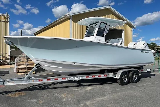 The Image of 2026 Sportsman Open 252 Center Console boat on trailer, parked outdoors under blue sky. - 0