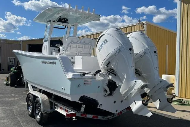 Slide: The Image of 2026 Sportsman Open 252 Center Console boat with dual engines on a trailer, under a clear sky. - 2