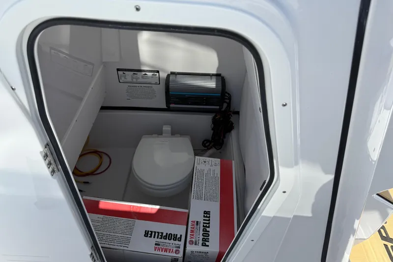 Slide: The Image of 2026 Sportsman Open 252 Center Console boat interior with toilet and Yamaha propeller box. - 13