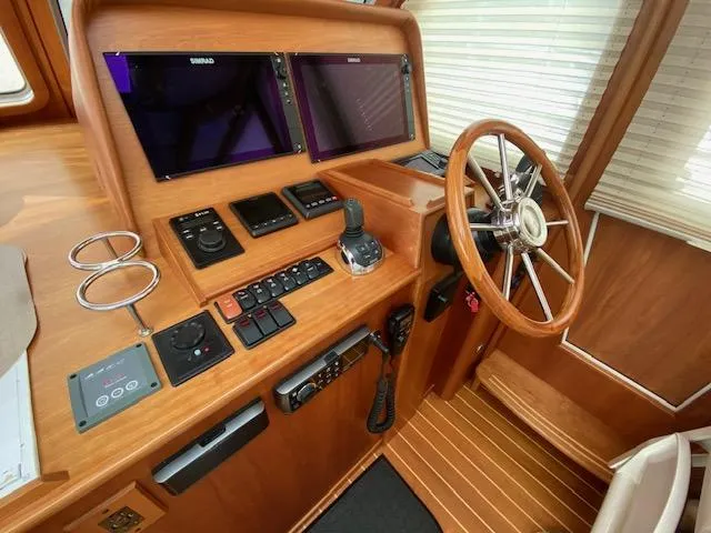 Slide: The Image of Helm station of 2015 Sabre 42 Salon Express with dual displays and wooden steering wheel. - 16