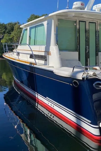 Slide: The Image of 2015 Sabre 42 Salon Express yacht with blue hull docked in calm water. - 2