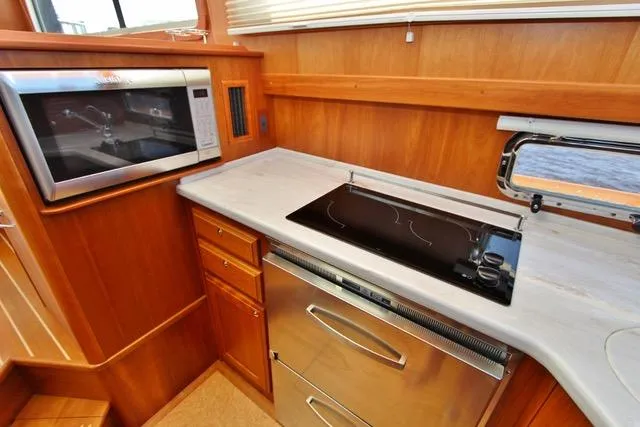 Slide: The Image of 2015 Sabre 42 Salon Express kitchen with microwave, stovetop, and stainless steel oven. - 25