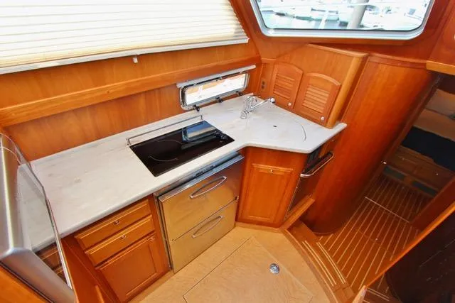 Slide: The Image of 2015 Sabre 42 Salon Express yacht kitchen with modern appliances and wooden cabinetry. - 27