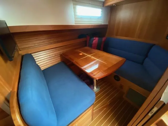 Slide: The Image of Interior dining area of 2015 Sabre 42 Salon Express with blue seating and wooden table. - 28
