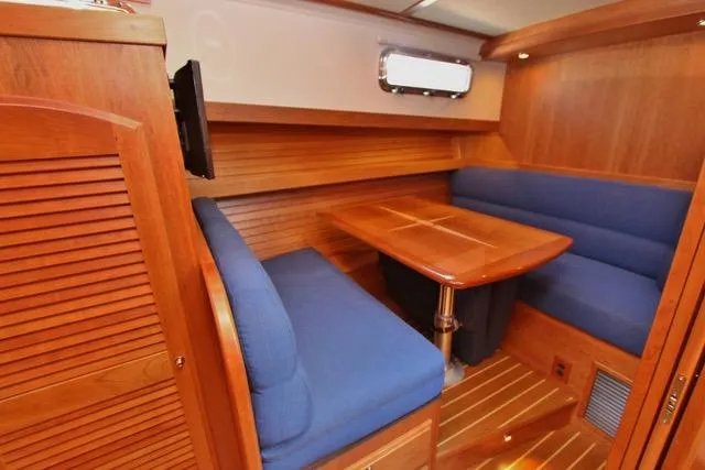 Slide: The Image of 2015 Sabre 42 Salon Express interior dining area with blue seating and wooden table. - 29