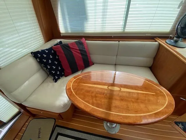 Slide: The Image of 2015 Sabre 42 Salon Express interior with cushioned seating and wooden table. - 31