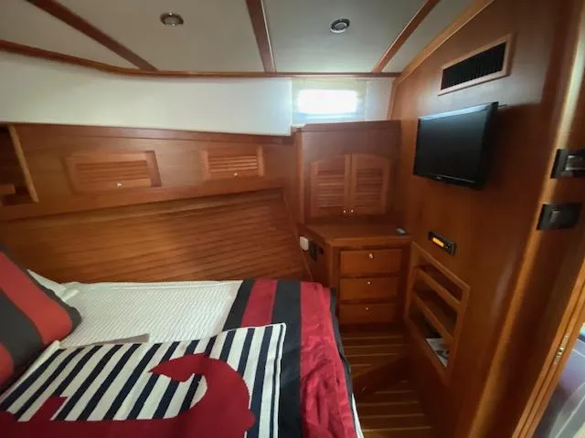 Slide: The Image of 2015 Sabre 42 Salon Express bedroom with wooden interior, bed, TV, and storage. - 33