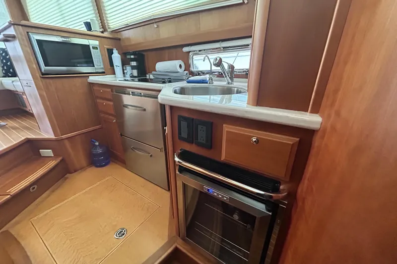 Slide: The Image of 2015 Sabre 42 Salon Express yacht kitchen with sink, microwave, and wooden cabinetry. - 37