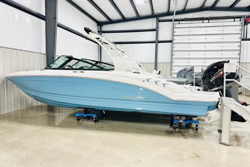 The Image of 2025 Chaparral 23 SSi OB boat in showroom, featuring sleek blue and white design. - 0