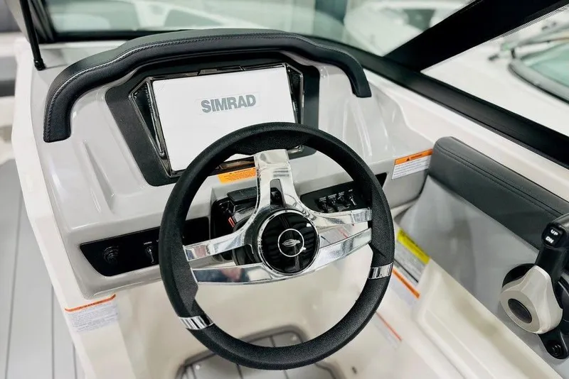 Slide: The Image of 2025 Chaparral 23 SSi OB boat dashboard with Simrad display and steering wheel. - 12
