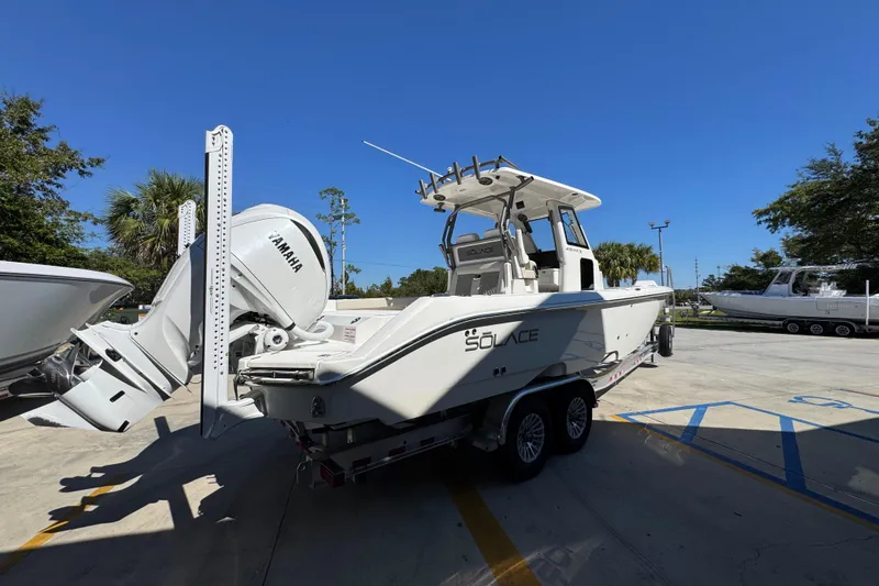 Slide: The Image of 2025 Solace 28 HCS boat on trailer with Yamaha engine, parked outdoors. - 11