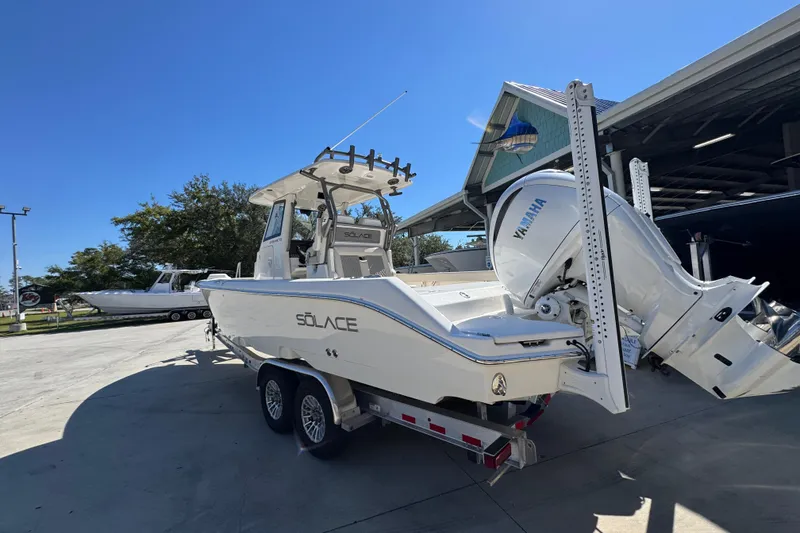 Slide: The Image of 2025 Solace 28 HCS boat on trailer with Yamaha engine, parked outdoors. - 15