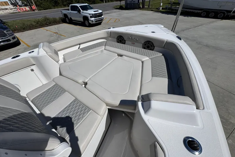 Slide: The Image of 2025 Solace 28 HCS boat with luxurious seating and modern design in a parking lot. - 16