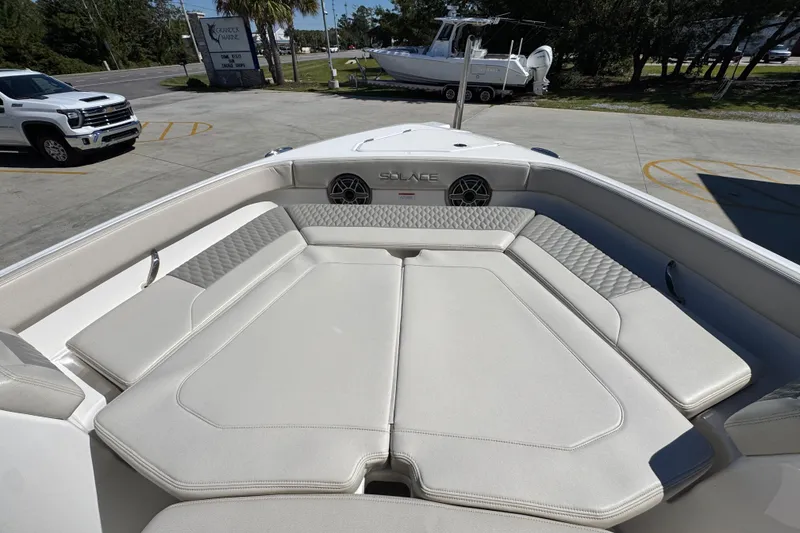 Slide: The Image of 2025 Solace 28 HCS boat with luxurious seating and modern design in a parking area. - 17