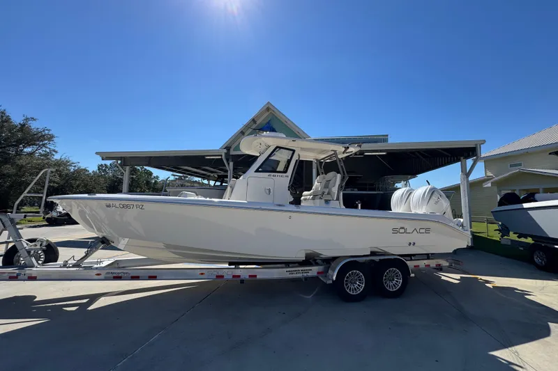 Slide: The Image of 2025 Solace 28 HCS boat on trailer under clear blue sky. - 2
