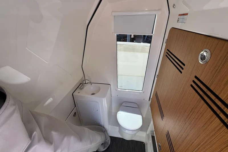 Slide: The Image of Compact bathroom interior of 2025 Solace 28 HCS boat with sink and toilet. - 24