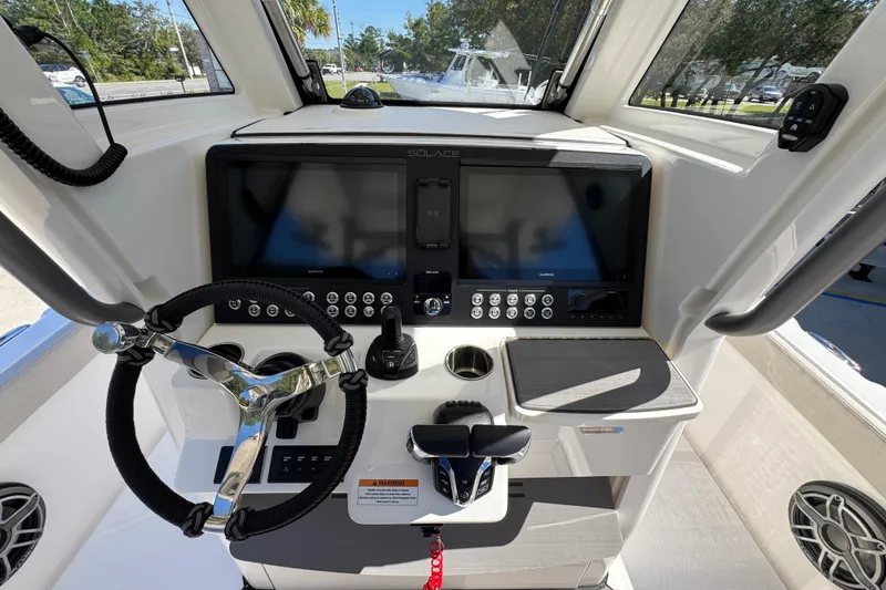 Slide: The Image of 2025 Solace 28 HCS boat helm with modern controls and navigation display. - 30