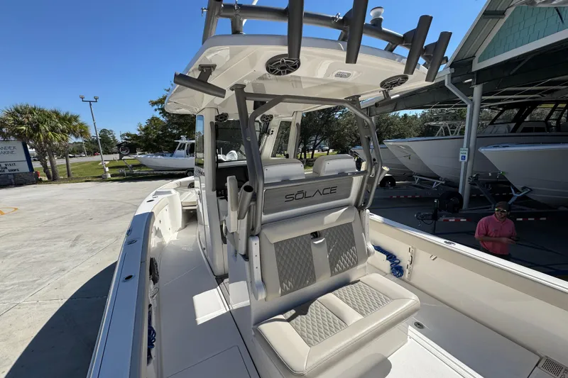 Slide: The Image of 2025 Solace 28 HCS boat interior with seating and rod holders, docked outdoors. - 33