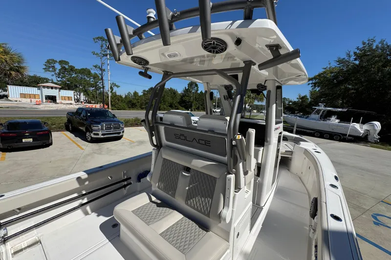 Slide: The Image of 2025 Solace 28 HCS boat interior with seating and helm, parked outdoors. - 35