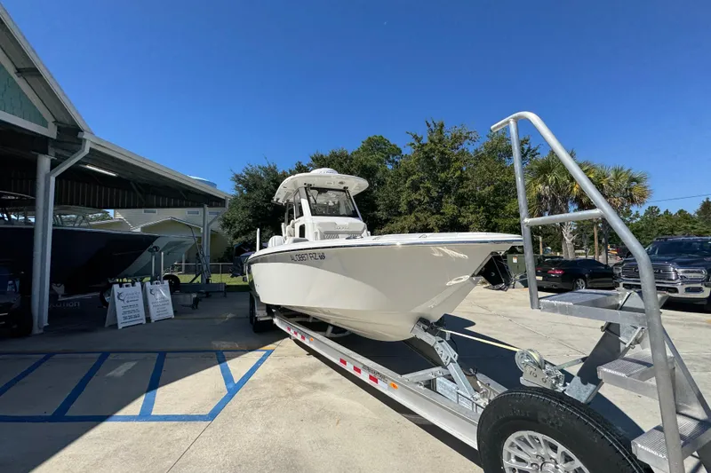 Slide: The Image of 2025 Solace 28 HCS boat on trailer, parked outdoors under clear blue sky. - 7