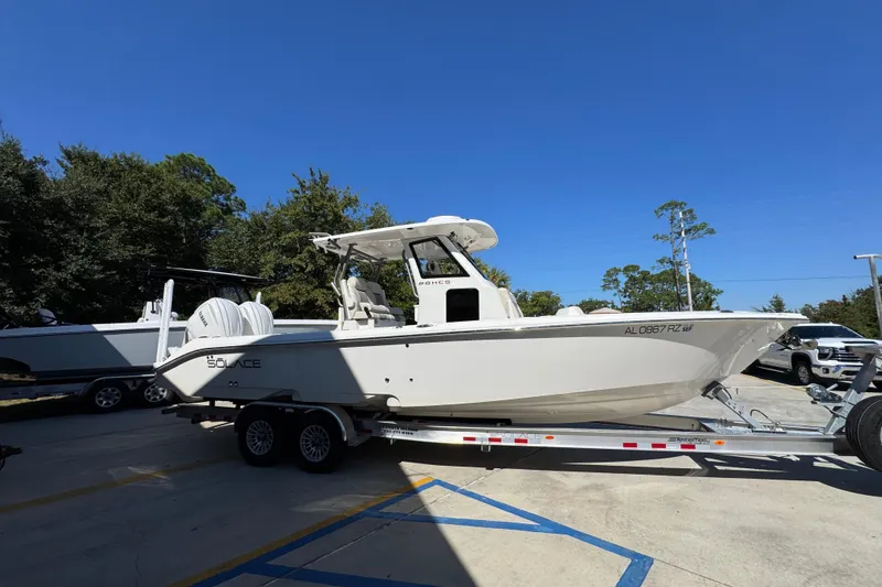 Slide: The Image of 2025 Solace 28 HCS boat on trailer, parked outdoors under clear blue sky. - 9