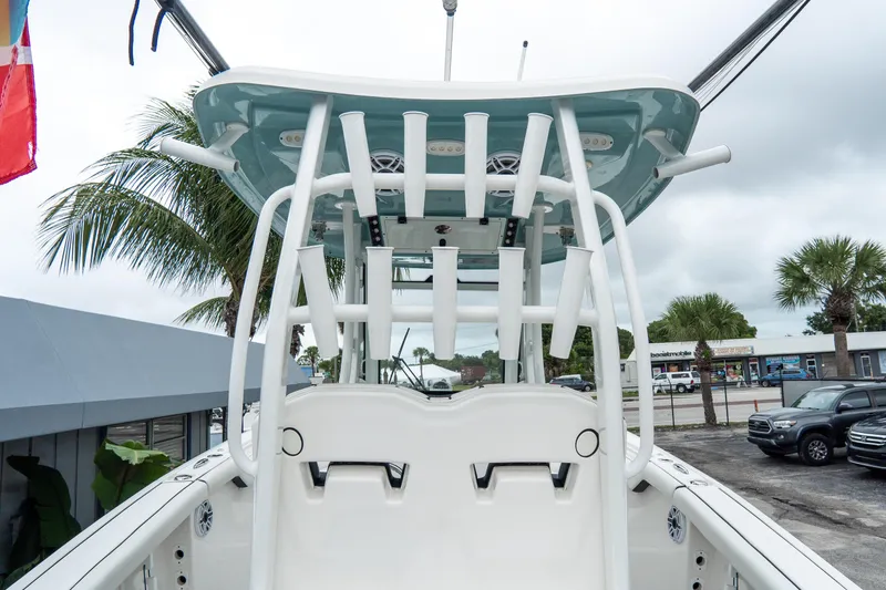 Slide: The Image of 2022 Tidewater 292 CC Adventure boat with rod holders and T-top, parked outdoors. - 11