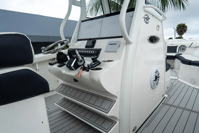 Slide: The Image of 2022 Tidewater 292 CC Adventure boat console with steering wheel and controls. - 20