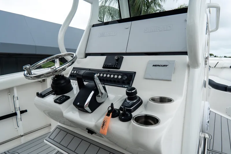 Slide: The Image of 2022 Tidewater 292 CC Adventure boat console with steering wheel and controls. - 21
