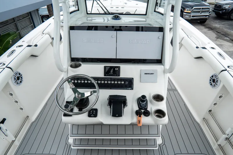 Slide: The Image of 2022 Tidewater 292 CC Adventure boat cockpit with steering wheel and control panel. - 22
