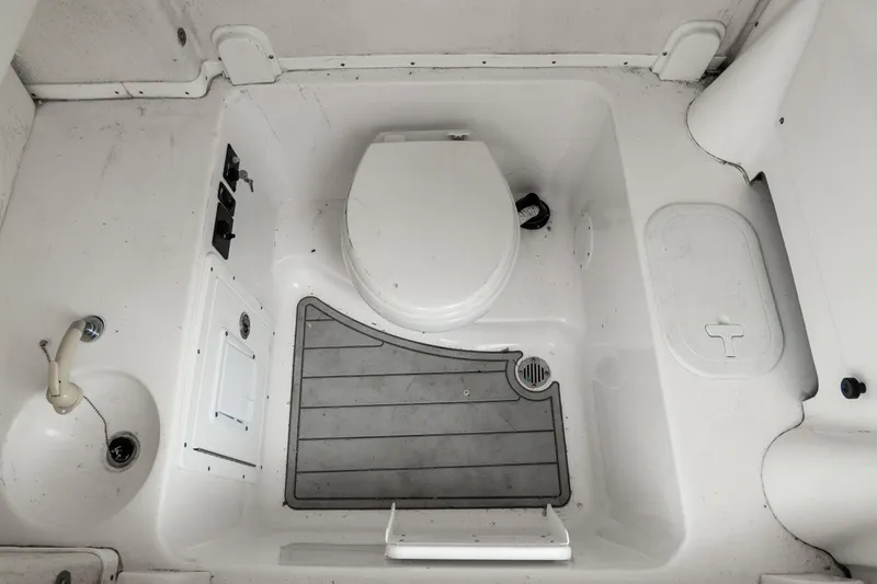 Slide: The Image of 2022 Tidewater 292 CC Adventure boat bathroom interior with toilet and sink. - 27