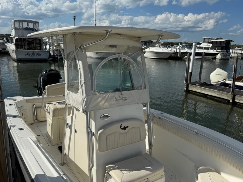 Slide: The Image of 2012 Mako 234 Center Console boat docked at marina under blue sky. - 2