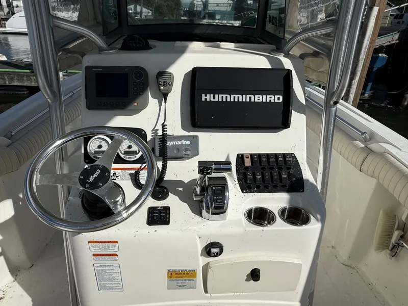 Slide: The Image of 2012 Mako 234 Center Console boat dashboard with steering wheel and navigation equipment. - 5