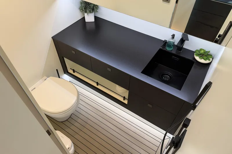 Slide: The Image of Modern bathroom in 2022 Vanquish VQ45 yacht with sleek black vanity and compact toilet. - 25