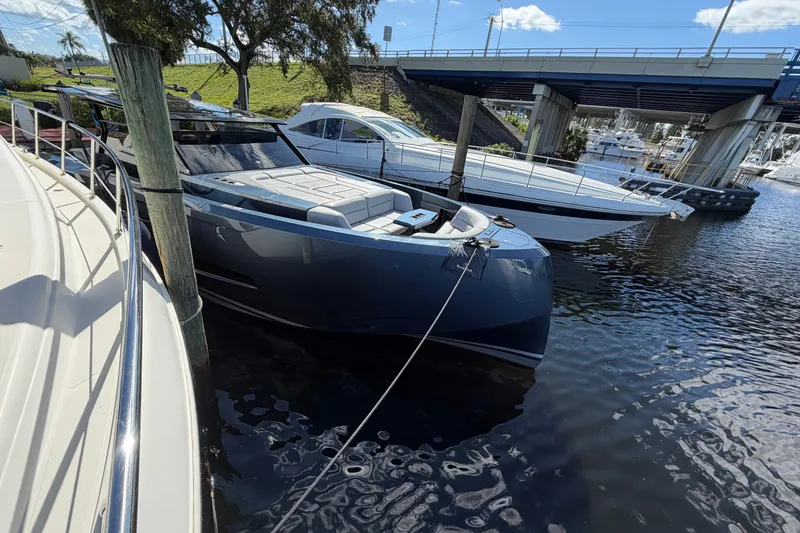 Slide: The Image of Luxury 2022 Vanquish VQ45 yacht docked near a bridge on a sunny day. - 3