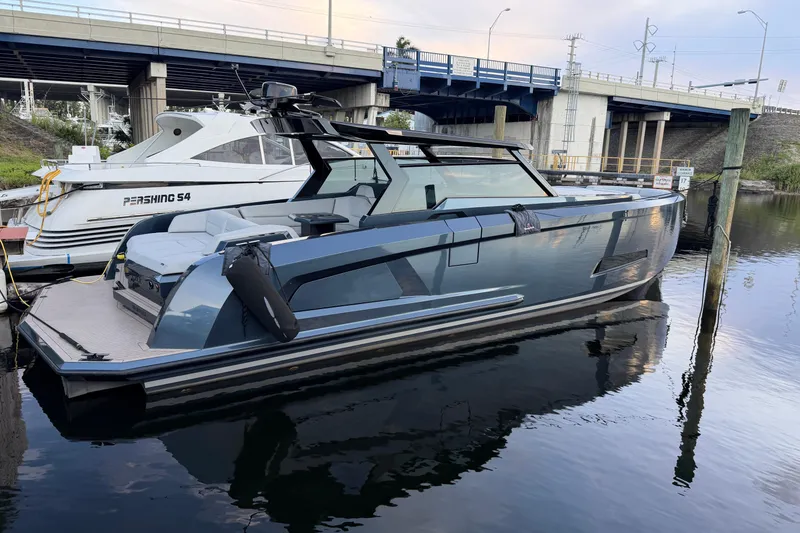 The Image of 2022 Vanquish VQ45 luxury yacht docked beside a Pershing S4 under a bridge. - 0