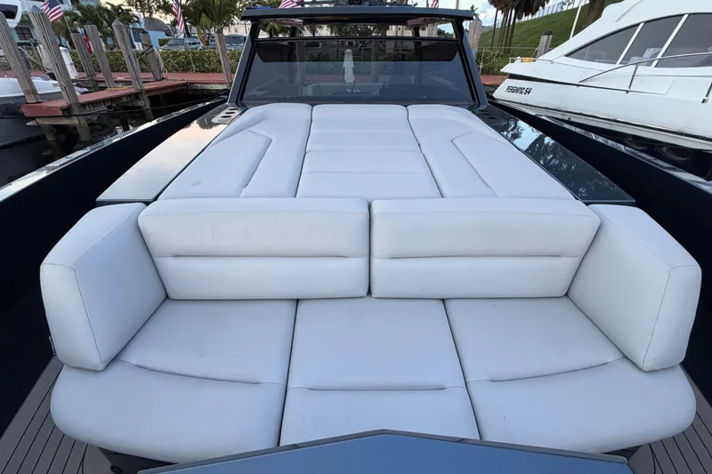 Slide: The Image of Luxurious white seating on 2022 Vanquish VQ45 yacht, docked with surrounding boats. - 27