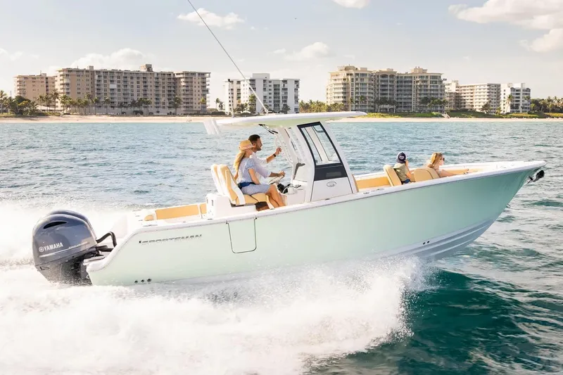 The Image of Manufacturer Provided Image: 2025 Sportsman Open 262 Center Console boat cruising on ocean near city skyline. - 0
