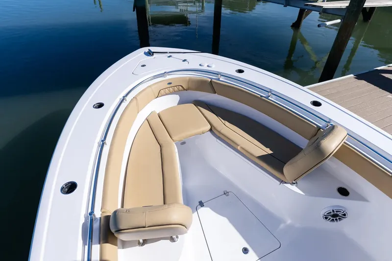 Slide: The Image of Manufacturer Provided Image: 2025 Sportsman Open 262 Center Console boat with tan seats, steering wheel, and calm water backdrop. - 10