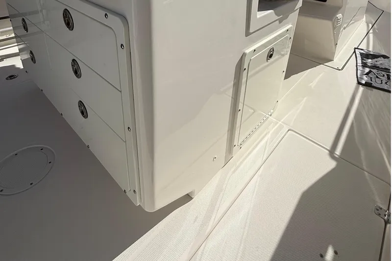 Slide: The Image of 2016 Edgewater 280CC boat interior with storage compartments and non-slip flooring. - 14