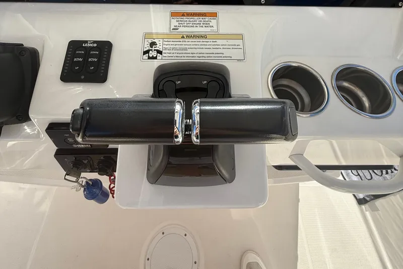 Slide: The Image of Control panel of a 2016 Edgewater 280CC boat with throttle and cup holders. - 17