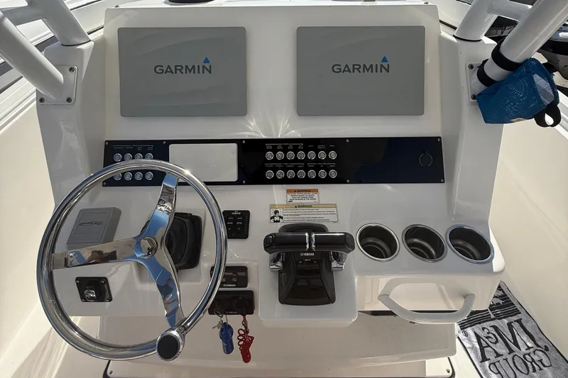 Slide: The Image of Edgewater 280CC 2016 boat dashboard with Garmin displays and steering wheel. - 19