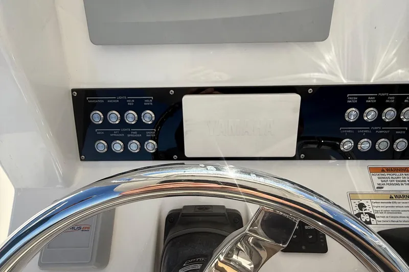 Slide: The Image of Control panel of a 2016 Edgewater 280CC boat with steering wheel and switches. - 21