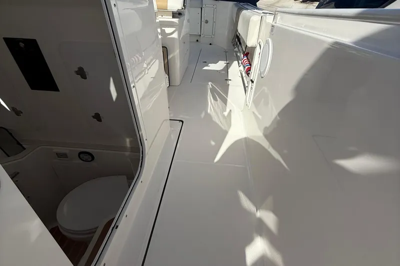 Slide: The Image of 2016 Edgewater 280CC boat interior with clean deck and visible toilet area. - 33